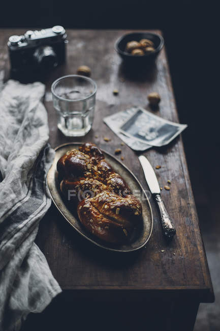 Домашнее сладкое плетеное тесто на тарелке на деревянном столе — стоковое фото