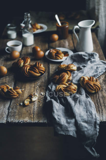 Homemade cinnamon buns on rustic wooden table — Stock Photo