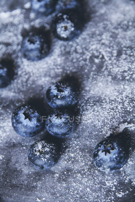 Close-up of fresh blueberries on grey surface — Stock Photo