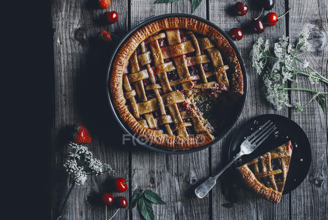Torta de baunilha caseira com cerejas e morangos em mesa de madeira rústica — Fotografia de Stock