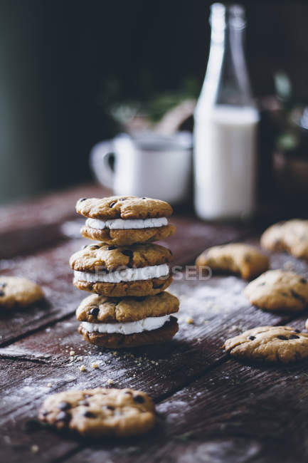 Stacked american chocolate chip cookies on dark wood — Stock Photo