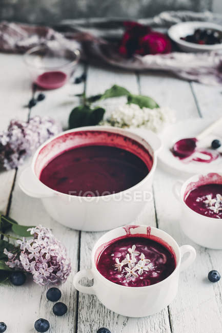 Homemade blueberry kissel in pan and in bowls on white wood — Stock Photo