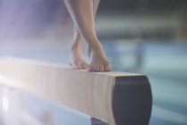 Bare feet of female gymnast performing on balance beam — Stock Photo