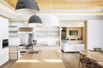 Moderne luci a sospensione su isola cucina in legno — Foto stock