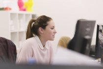 Бізнес-леді, що працює за комп'ютером в сучасному офісі — стокове фото