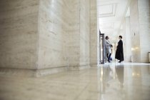 Lawyer and judge talking in hallway of courthouse — Stock Photo