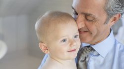 Усміхнений батько тримає дитину — стокове фото