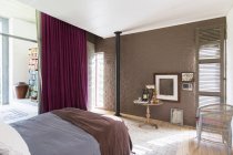 Bett, Beistelltisch und Bilder im rustikalen Schlafzimmer — Stockfoto