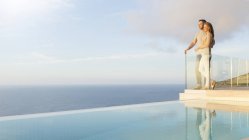 Пара з видом на океан з сучасного балкона — стокове фото