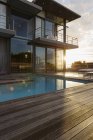 Soleil derrière maison de luxe avec piscine — Photo de stock
