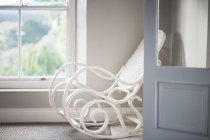 Антикварное кресло-качалка в углу у окна — стоковое фото