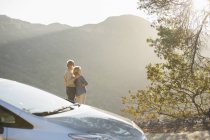 Senior couple looking at mountain view outside car — Stock Photo