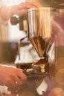 Cropped image of barista using espresso machine grinder — Stock Photo