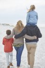Familia caminando en la playa de invierno - foto de stock