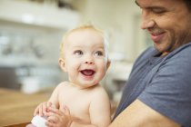 Father holding baby in kitchen — Stock Photo