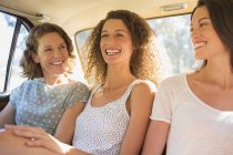 Trois femmes assises ensemble sur le siège arrière de la voiture — Photo de stock
