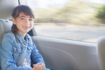 Portrait de fille heureuse sur le siège arrière de la voiture — Photo de stock