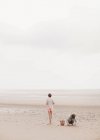 Irmão e irmã brincando na areia na praia nublada de verão — Fotografia de Stock
