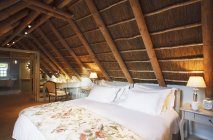 Camera da letto sottotetto di lusso sotto tetto in legno — Foto stock