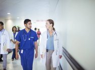 Врач и медсестра разговаривают в коридоре больницы — стоковое фото