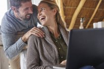 Glückliches Paar lacht und benutzt Laptop — Stockfoto