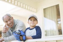 Abuelo y nieto con guante de béisbol en el porche - foto de stock