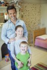 Father and children smiling in bedroom — Stock Photo