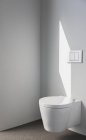Сонячне світло на стіні над сучасним туалетом у ванній — стокове фото