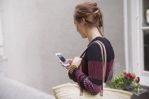 Frau chattet mit Handy in Gasse — Stockfoto