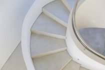 Bianco, scala a chiocciola in cemento moderno interno vetrina — Foto stock