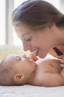 Mother playing with baby boy on table — Stock Photo