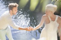 Пара тримає руки біля басейну на відкритому повітрі — стокове фото