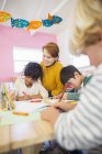 Students and teacher drawing in classroom — Stock Photo