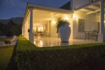 Casa de lujo con porche iluminado por la noche - foto de stock