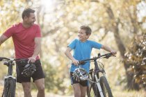 Батько і син ходьба гірські велосипеди в лісі — стокове фото