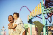 Couple enthousiaste étreignant au parc d'attractions — Photo de stock