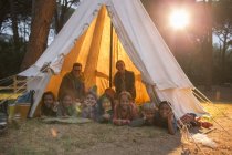 Students and teachers smiling in teepee at campsite — Stock Photo
