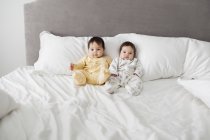 Twin adorabili neonate sedute sul letto — Foto stock
