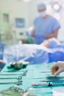 Infermiera che organizza strumenti chirurgici su vassoio in sala operatoria — Foto stock