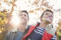 Father in son below sunny autumn tree — Stock Photo