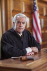 Судья сидит на скамейке судей в суде — стоковое фото