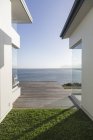 Modern home showcase exterior courtyard with sunny, tranquil ocean view — Stock Photo