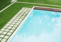 Pedras de pavimentação em uma fileira ao longo da piscina no quintal — Fotografia de Stock