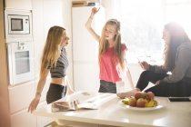 Adolescentes bailando en cocina soleada - foto de stock