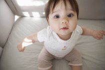 Baby girl sitting up in crib — Stock Photo