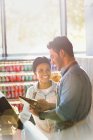 Arbeiter lächeln und reden an der Supermarkt-Kasse — Stockfoto