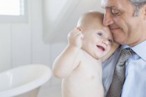Father holding baby in bathroom — Stock Photo