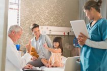 Doctor making rounds, gesturing with girl patient in hospital room — Stock Photo