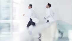 Médicos corriendo en el pasillo del hospital - foto de stock