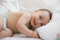 Bébé garçon couché sur le lit et regardant caméra — Photo de stock